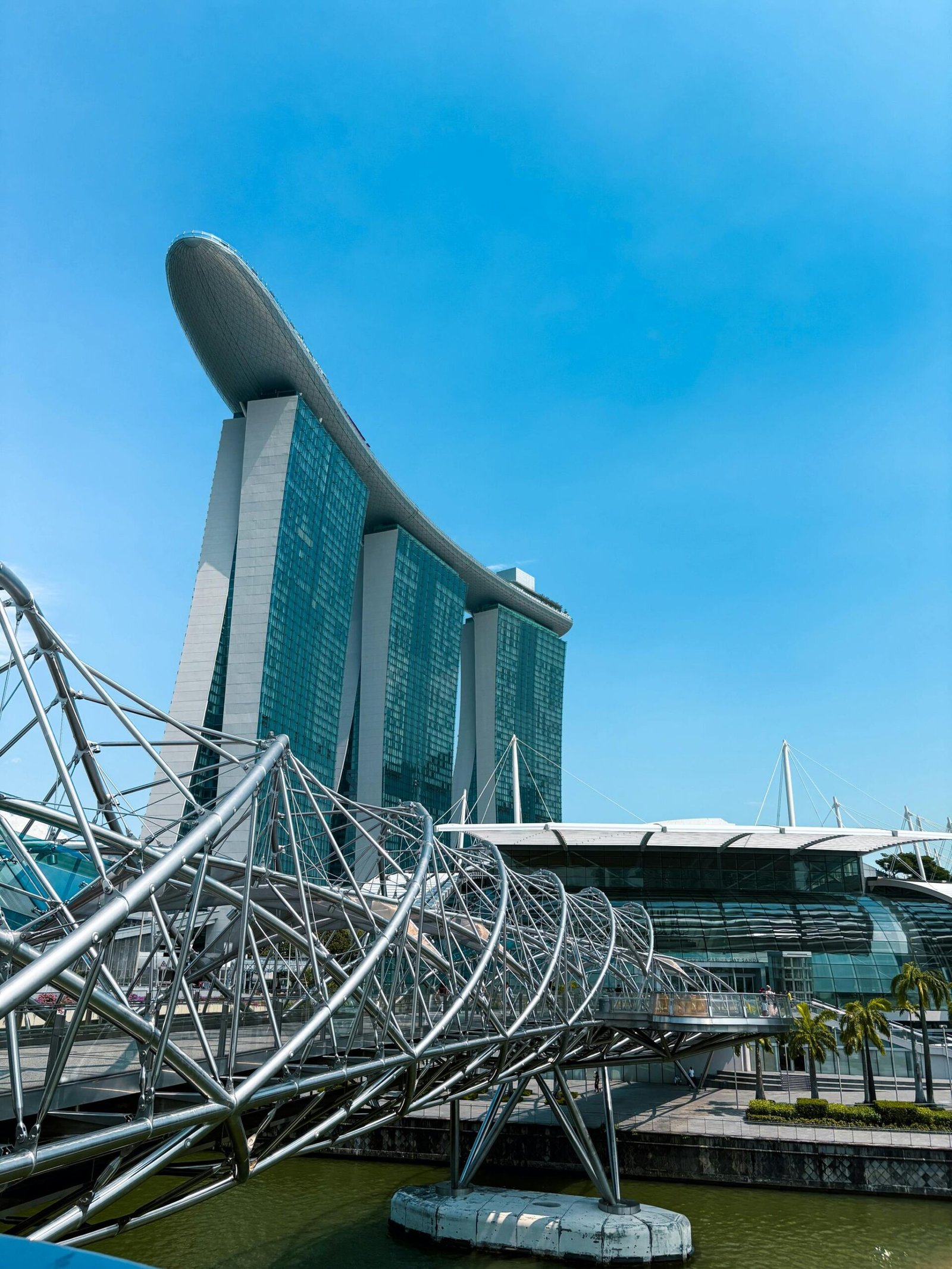 Stunning view of Marina Bay Sands with the Helix Bridge in Singapore under clear blue skies.